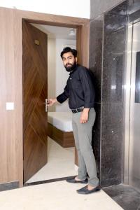 a man standing in a door in a room at Hotel MM Palace Vairo Cafe Rooftop View Taj Mahal in Tājganj