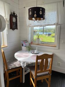 a dining room table with two chairs and a window at Brinken 3 in Sörberge +4 photos