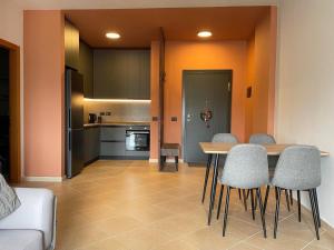 a kitchen and dining room with a table and chairs at Luxury Bruchi in Durrës