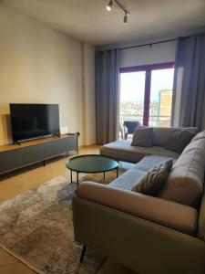 a living room with a couch and a flat screen tv at Luxury Bruchi in Durrës
