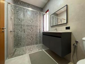 a bathroom with a shower with a sink and a mirror at Luxury Bruchi in Durrës +10 photos