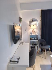 a living room with a television and a chair at Résidence Le poisson d'or in Perros-Guirec