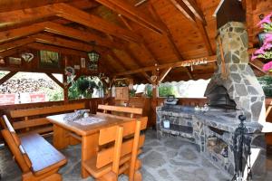 an outdoor dining area of a cabin with a fireplace at PRIVAT MARIANNA in Žakovce