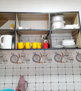 a kitchen shelf with bowls and plates on it at Mwembeni Abode in Bamburi +3 photos