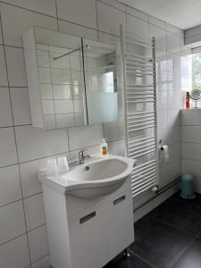 a white bathroom with a sink and a mirror at Heavenlywell in Geel +154 photos