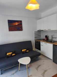 ein Wohnzimmer mit einer blauen Couch in einer Küche in der Unterkunft Apartment Mitko in Ofrynio