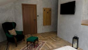 a room with a television and a chair and a table at Avala apartments in Beli Potok
