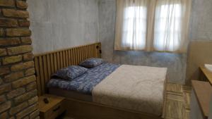 a bedroom with a bed and a brick wall at Avala apartments in Beli Potok