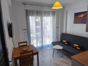 ein Wohnzimmer mit einem blauen Sofa und einem Tisch in der Unterkunft Apartment Mitko in Ofrynio