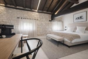 a bedroom with a bed and a table and a chair at Hotel El Paraíso del Pas in Barcenilla
