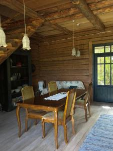a dining room with a wooden table and chairs at Urikivi Holiday House in Orjaku