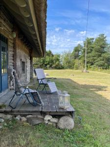 a porch with two chairs and a table and a table and chairs at Urikivi Holiday House in Orjaku