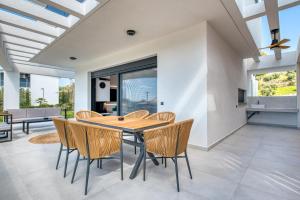 a dining room with a wooden table and chairs at Inception Luxury Villas in Nea Skioni
