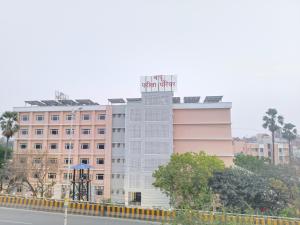 a white building with a sign on top of it at Rupali Guest House in Patna