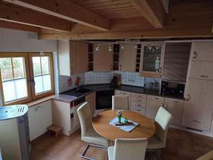 a kitchen with a wooden table and chairs and a table at Haus Gemütlichkeit in Schotten