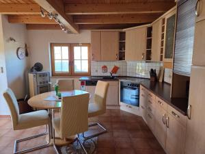 a kitchen with a table and a table and chairs at Haus Gemütlichkeit in Schotten