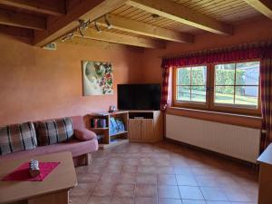 a living room with a couch and a television at Haus Gemütlichkeit in Schotten +3 photos
