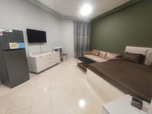 a living room with a couch and a television at Cozy Studio In Orient Towers Ajman in Ajman 