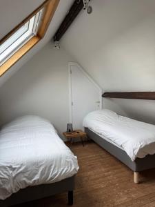 a bedroom with two beds and a window at Heavenlywell in Geel