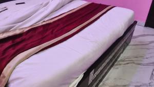 a close up of a bed with white sheets at Hotel rishav prime in Ghaziabad