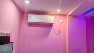 a room with a pink wall with a hair dryer at Hotel rishav prime in Ghaziabad