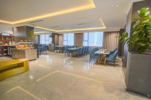 a restaurant with blue chairs and tables in a lobby at Grand Iva Hotel Abha in Abha