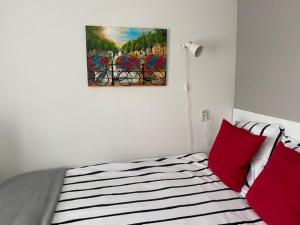 ein Schlafzimmer mit einem Bett mit roten Kissen und einem Gemälde in der Unterkunft Valckesteyn in Poortugaal