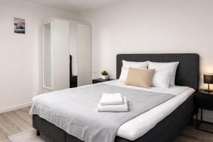 a bedroom with a large bed with two towels on it at MIILOX Apartments Chemnitz Hainstrasse in Chemnitz