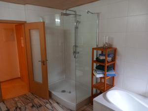 a bathroom with a shower and a tub and a sink at Ferienwohnung Linke "Grünblick" in Grimma +5 photos