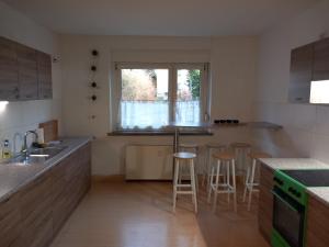 a kitchen with a sink and a counter with stools at Ferienwohnung Linke "Grünblick" in Grimma