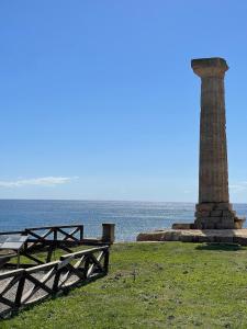 a lighthouse and picnic tables in front of the ocean at Regina Margherita in Crotone