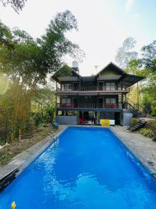 a house with a swimming pool in front of a house at Stillora Hotel And Resorts in Sultan Bathery +6 photos