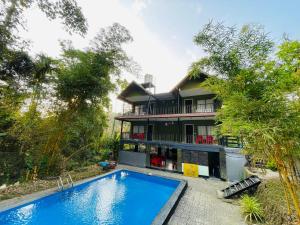 a house with a swimming pool in front of it at Stillora Hotel And Resorts in Sultan Bathery