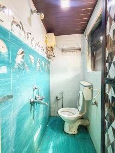 a bathroom with a toilet and a painting on the wall at Hotel Krantiveer in Kālundri