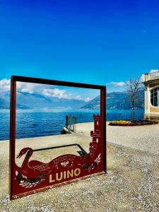 a sign sitting on the ground next to the water at Blueberry Villa - Historic Center Lago Maggiore in Luino