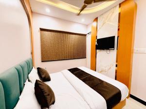 a bedroom with a bed and a tv in it at Hotel Hira Palace in Ujjain