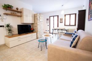 a living room with a couch and a tv at Blueberry Villa - Historic Center Lago Maggiore in Luino