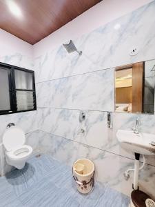 a white bathroom with a toilet and a sink at Hotel Hira Palace in Ujjain +35 photos