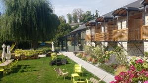 a garden with chairs and tables and a building at Logis SPA Hotel Restaurant De La Poste in Tence