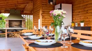 a table with wine glasses and a vase of flowers at Villa AD Astra by Villas Guide in Sesvete
