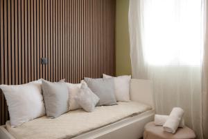 a white couch with pillows sitting in a window at El Koulador House in Ialysos