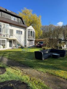 a house with a black couch in the yard at Heavenlywell in Geel