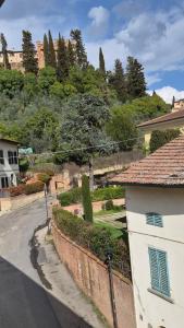 an empty street with a building and a hill with trees at La Perla del Boccaccio in Certaldo