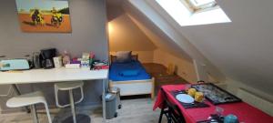 a room with a bed and a desk in a attic at Les nichoirs - Appartemment à Vouvray in Vouvray