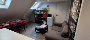 a small living room with a couch and a table at Les nichoirs - Appartemment à Vouvray in Vouvray +13 photos