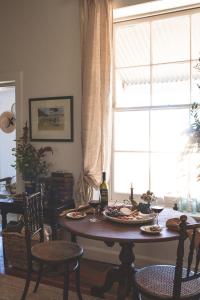 a dining room table with wine glasses and a window at Way's Cottage in McLaren Vale +13 photos
