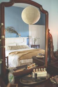 a bedroom with a bed with a mirror and a table at Way's Cottage in McLaren Vale