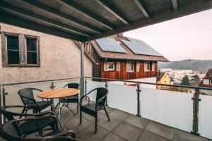 a balcony with a table and chairs and a house with solar panels at Haus im Garten in Stockach