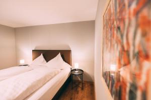 a bedroom with a white bed and a side table at Haus im Garten in Stockach