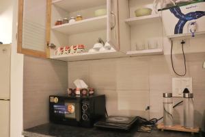 a kitchen with a microwave on a counter top at Gypsy Soul Gateaway in Zirakpur